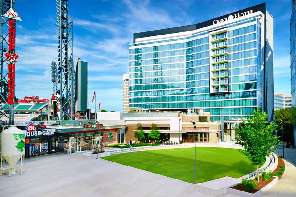Modern hotel building with green lawn courtyard and entertainment district signage