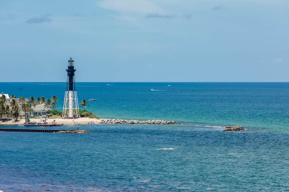 Lighthouse on a tropical beach with turquoise ocean water and white sand