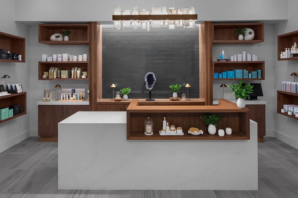Modern spa retail counter with wooden shelving, cosmetic products, and decorative elements