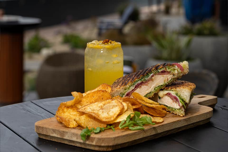 Gourmet sandwich plated with crispy fries and fresh lemonade served at resort poolside