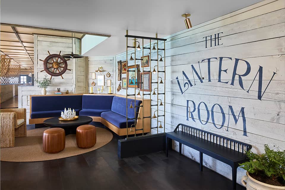 Nautical-themed lobby with blue seating, ship wheel decor, and 'The Lantern Room' sign