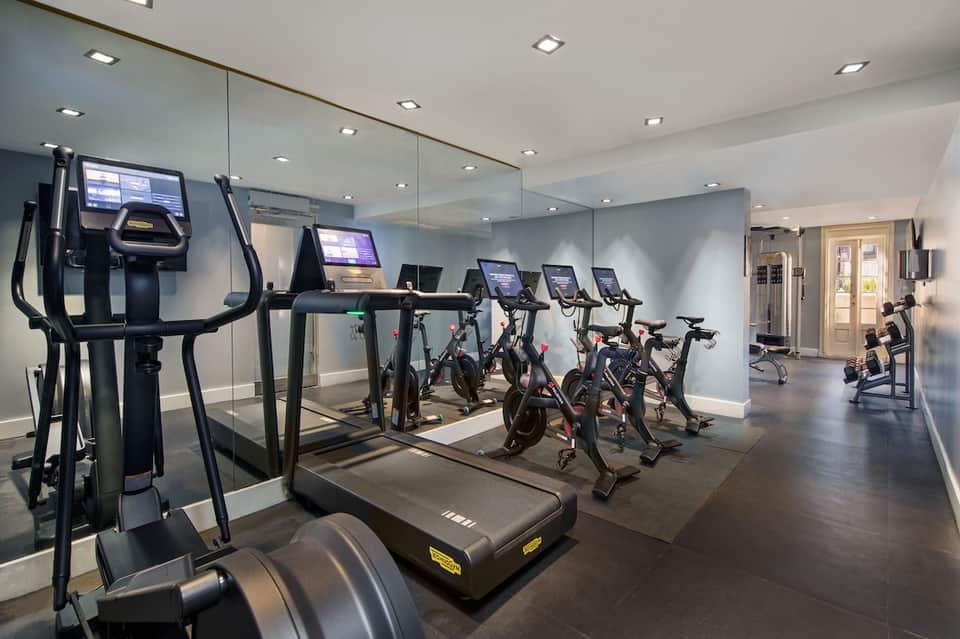 Fitness center with cardio equipment, stationary bikes, treadmills, exercise machines, and mirrored walls