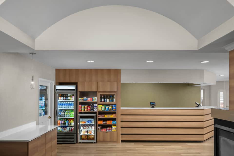 Modern hotel reception area with wooden elements, vending machines, and clean design