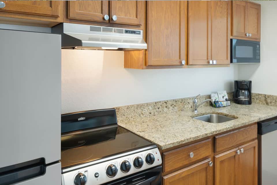 Kitchen interior with wood cabinets, granite countertops, and stainless steel appliances
