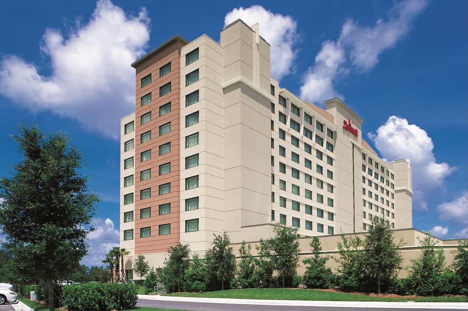 Marriott hotel exterior with red brick and cream colored facade against blue sky with trees