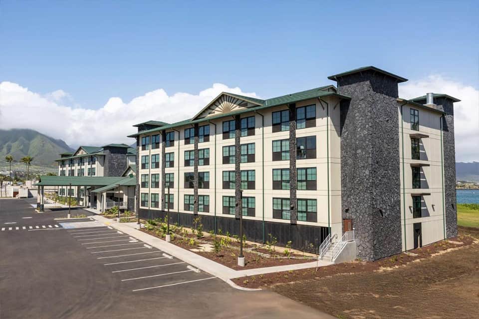 Multi-story residential hotel building with cream and stone exterior near ocean