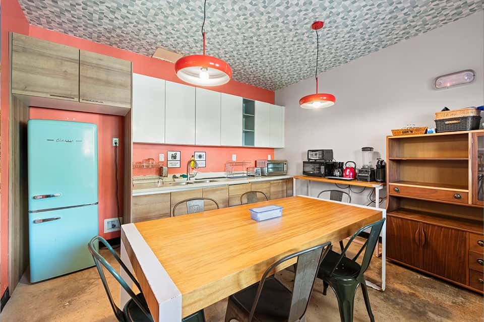 Retro-style kitchen with turquoise refrigerator, coral accents, and geometric ceiling pattern