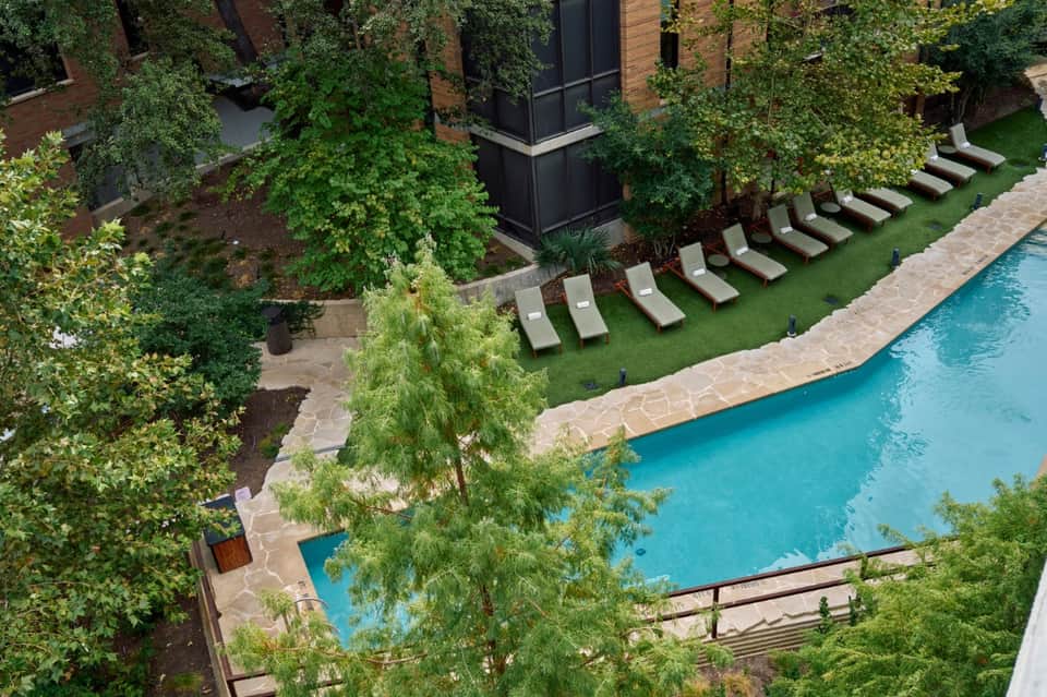 Aerial view of courtyard pool surrounded by lush greenery and modern architecture
