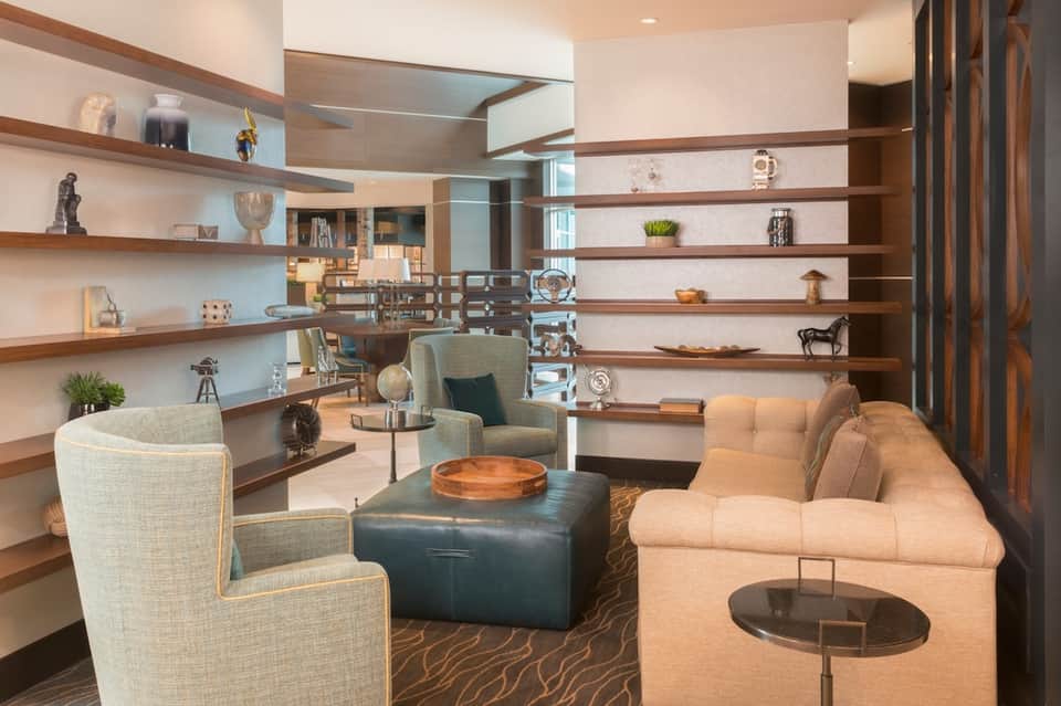 Upscale lounge with floating wood shelves, contemporary furniture, and decorative accessories