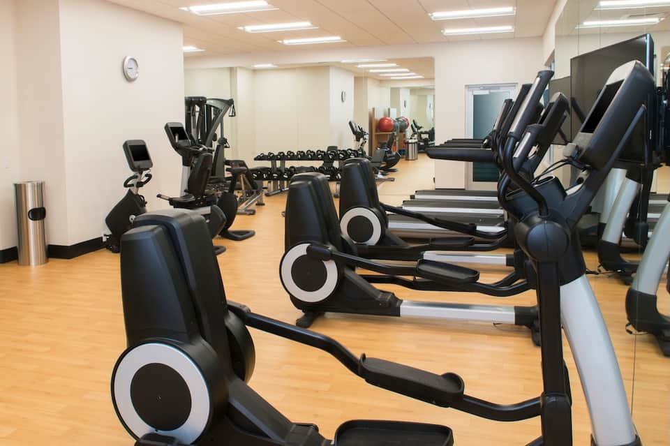 Modern fitness center with exercise bikes and cardio equipment on wooden floor