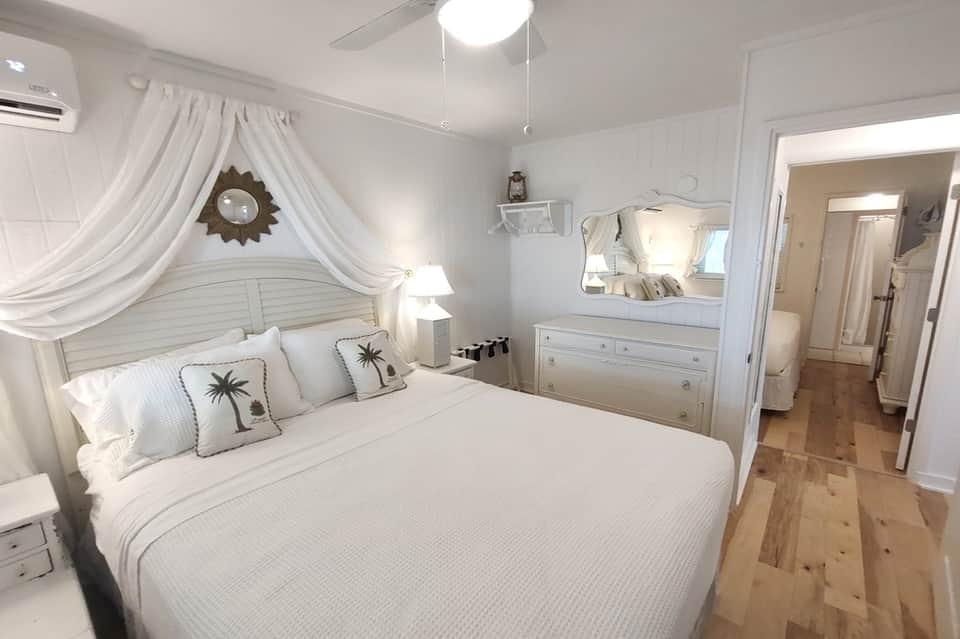 Coastal-themed bedroom with canopy bed and white furnishings