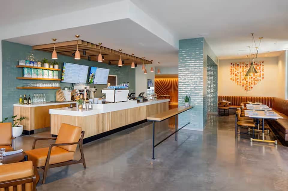 Modern hotel lobby with turquoise tile walls, wooden elements, and contemporary bar area