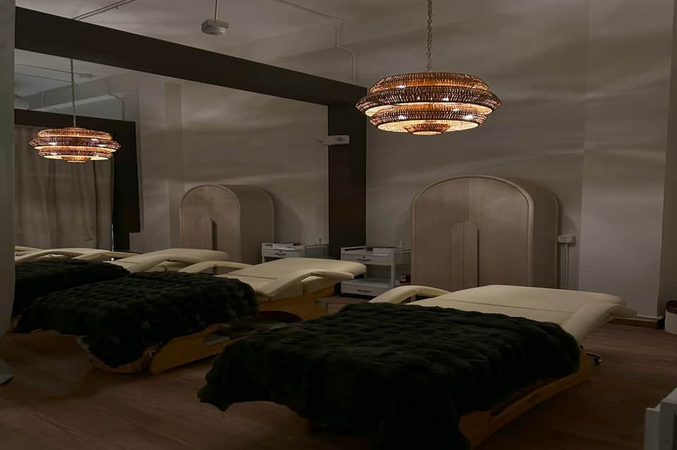 Contemporary hotel bedroom with two beds, mirror headboards, and woven pendant lights
