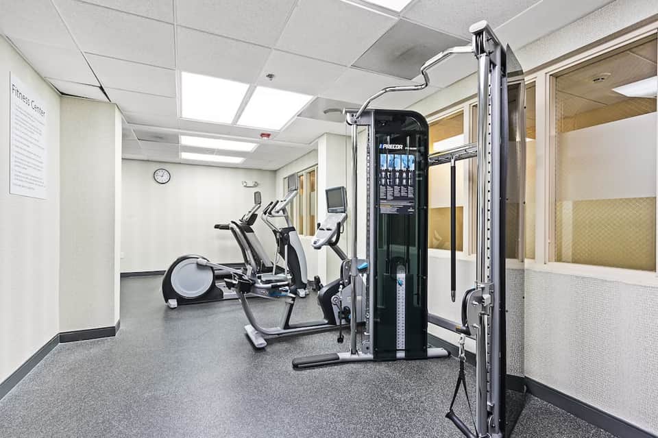 Hotel fitness center with exercise equipment including elliptical machines and weight training apparatus