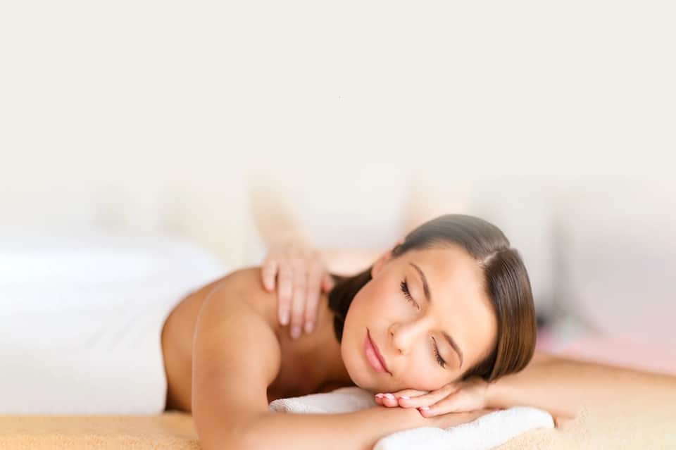 Woman receiving spa massage on treatment table in wellness facility