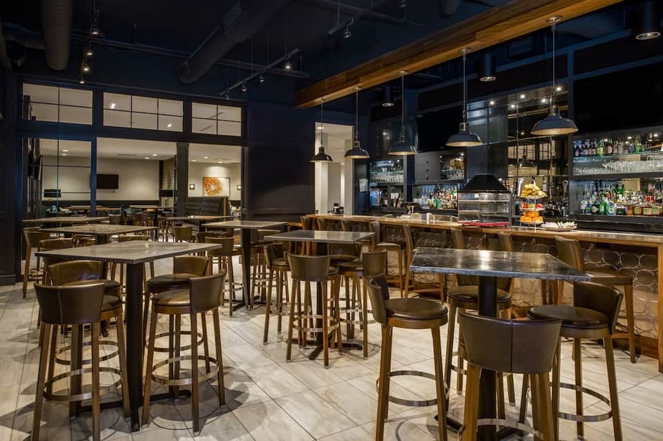 Modern hotel bar and lounge with wood accents and pendant lighting