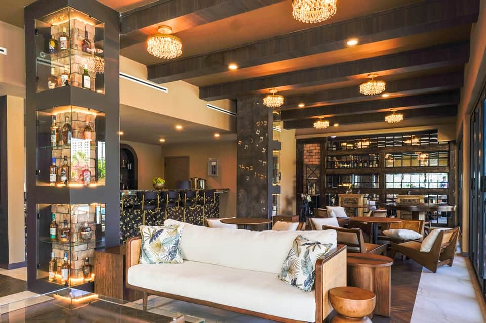 Luxury hotel lobby lounge with crystal chandeliers, wood accents, and bar area