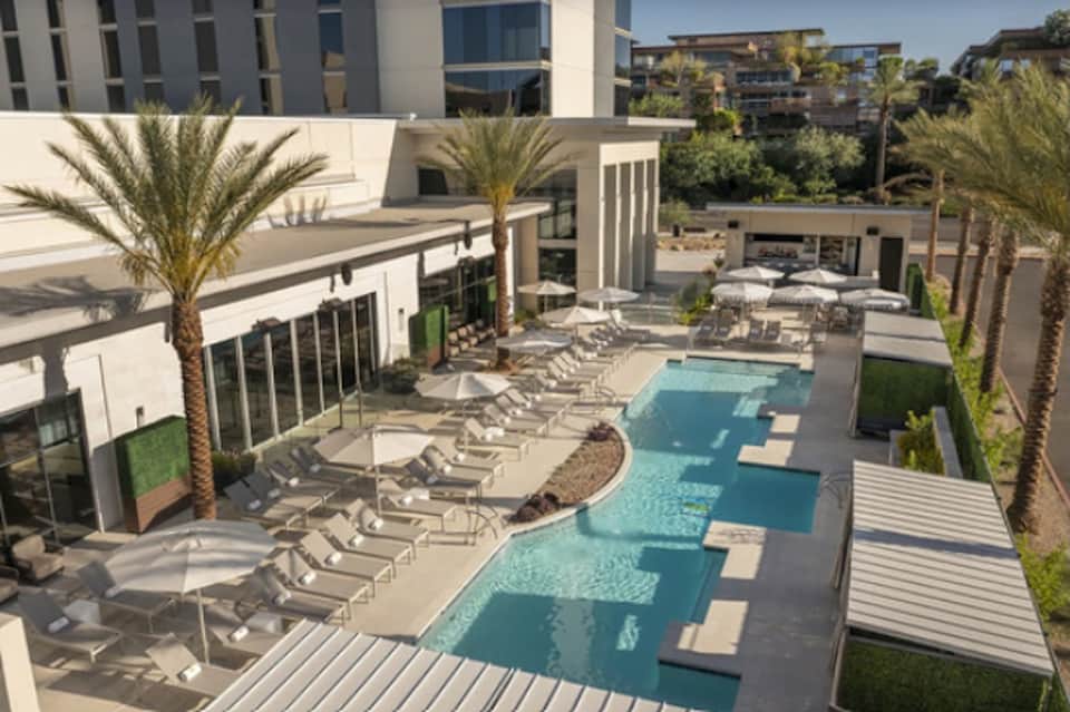 Resort courtyard aerial view with lagoon-style pool, lounge chairs, and palms