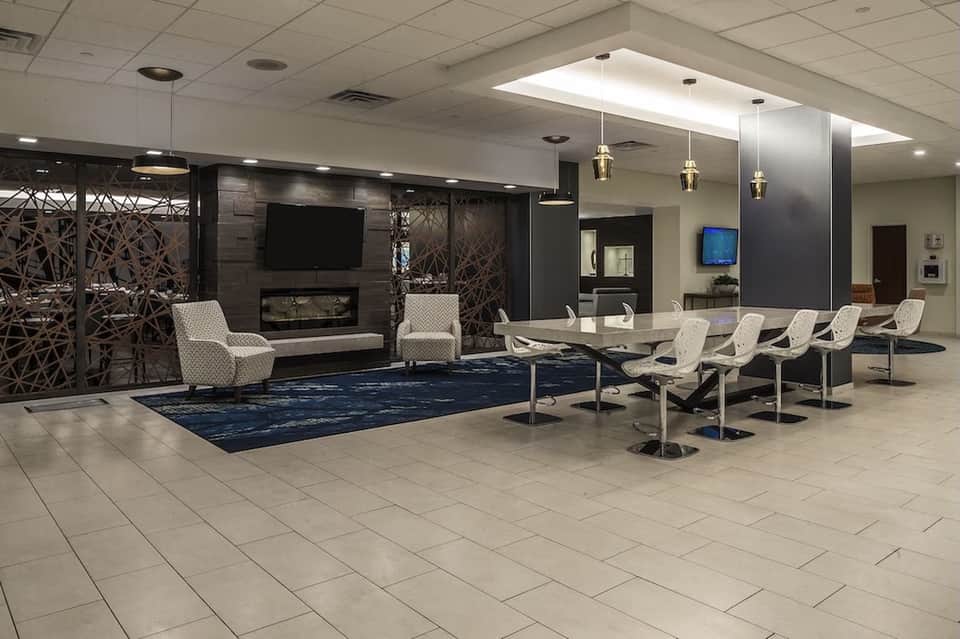 Modern hotel lobby with fireplace, comfortable seating, and contemporary lighting fixtures