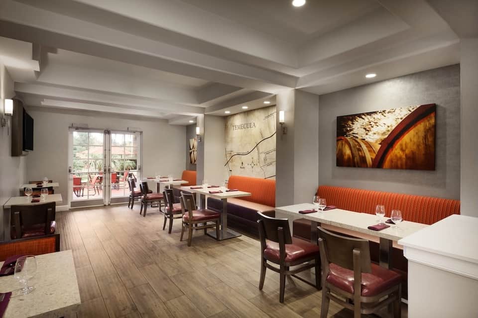 Fine dining restaurant interior with wood accents and orange upholstered seating
