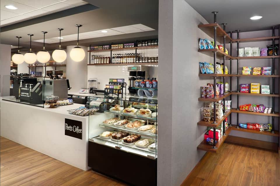 Modern coffee shop interior with display cases, pendant lighting, and retail shelves