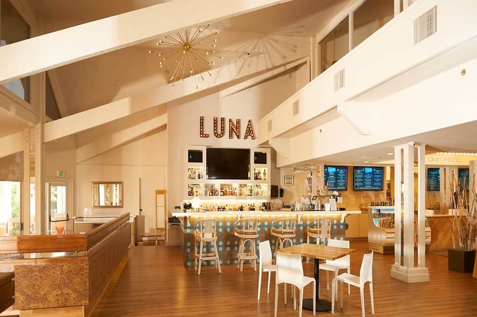 Modern restaurant lounge Luna with wooden floors, bar seating, and bright airy interior