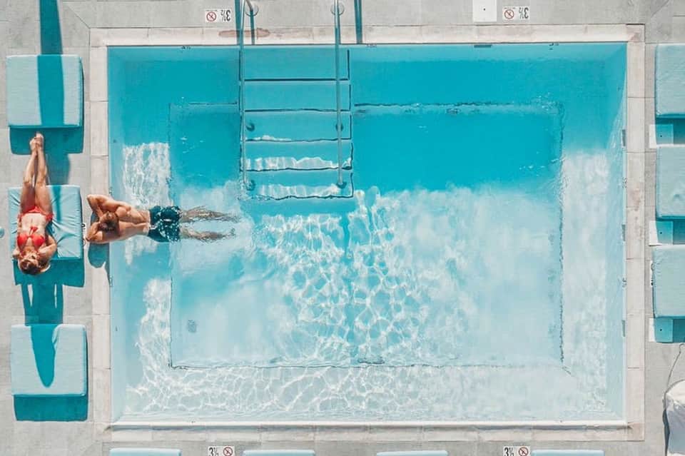 Aerial view of swimmer doing lap in rectangular pool with ladder and lane markers