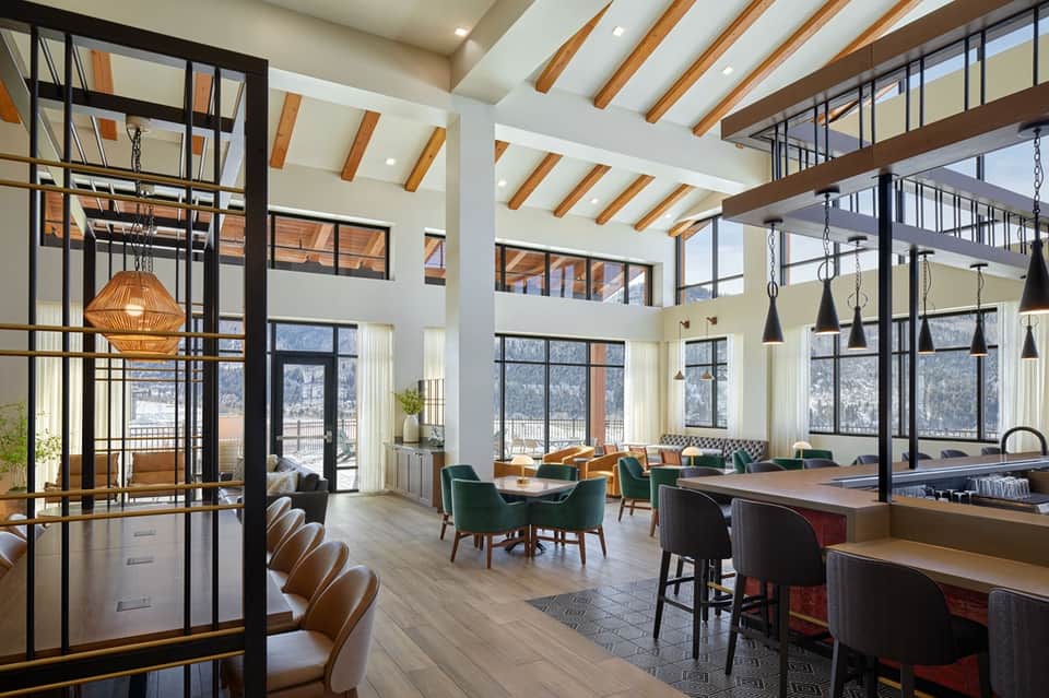 Modern hotel lobby with exposed wood beams, pendant lights and contemporary seating