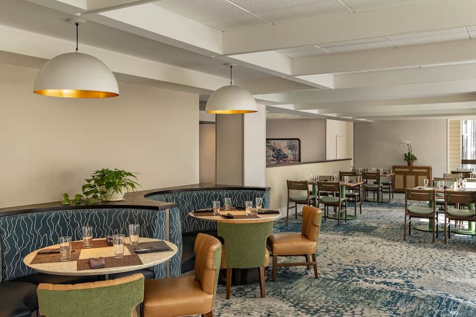 Modern restaurant lounge with wave-pattern banquettes, dome pendant lights, and wood tables