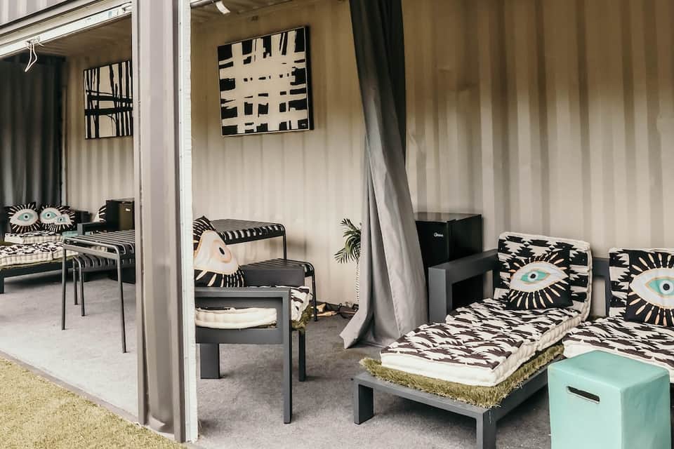 Modern spa cabana with black and white geometric patterned bedding and sheer curtains