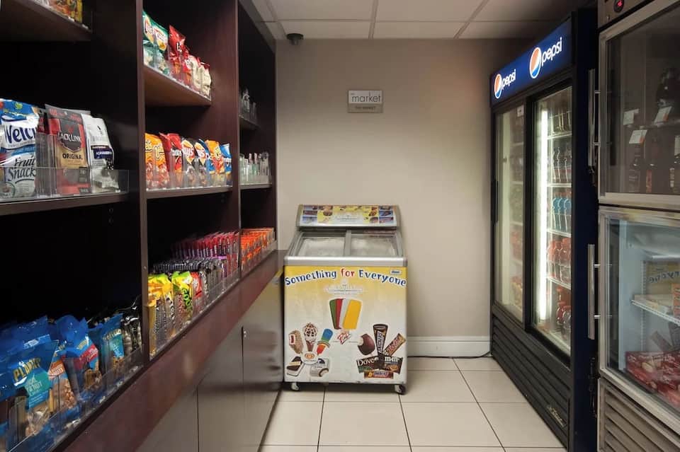 Hotel market interior with snack shelves, beverage coolers, and vending machines