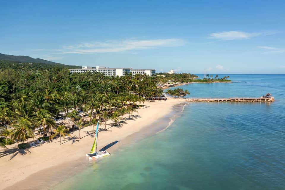 Beachfront resort on tropical island with white buildings and pristine sandy beach