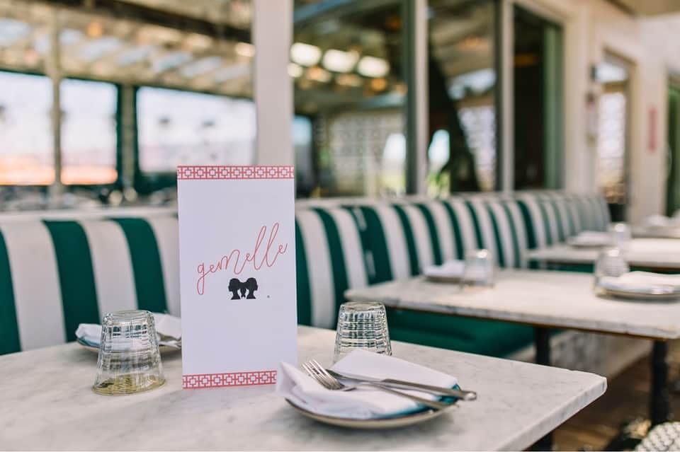 Elegant dining table setting with striped green and white chairs and water view
