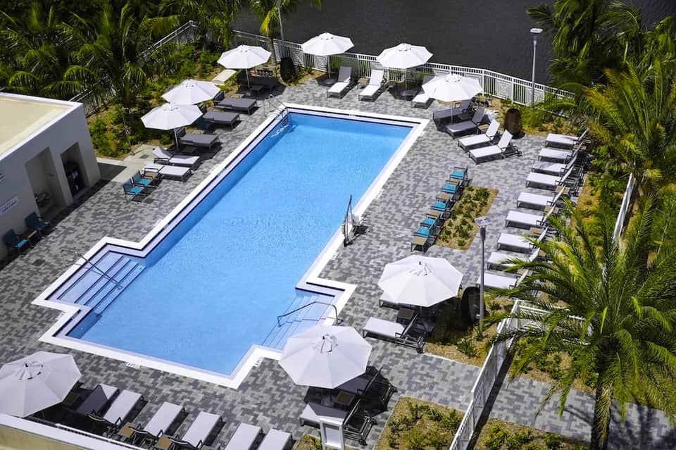 Aerial view of rectangular pool with loungers and white umbrellas