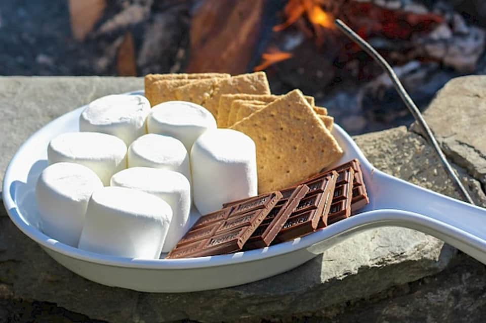 S'mores setup with marshmallows, graham crackers, and chocolate by campfire