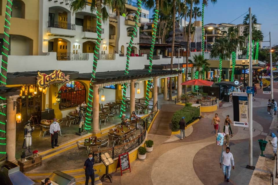 Colorful beachfront promenade with restaurants, decorative columns, and Mediterranean-style buildings