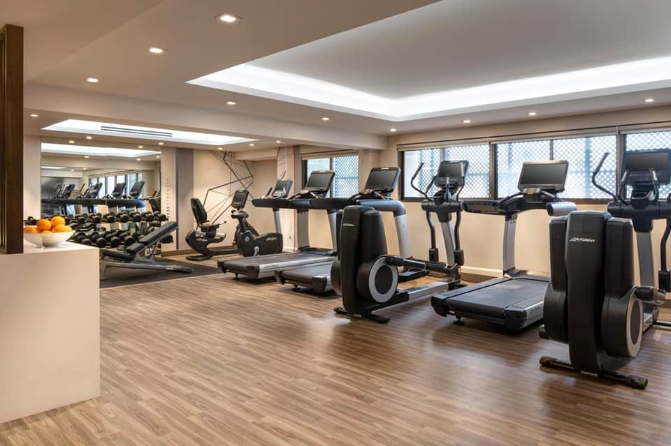 Modern fitness center with cardio equipment, treadmills, and floor-to-ceiling windows