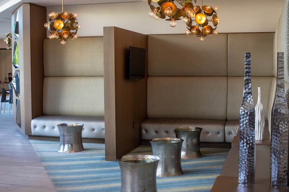 Modern lounge area with booth seating, decorative pendant lights, and metallic accents