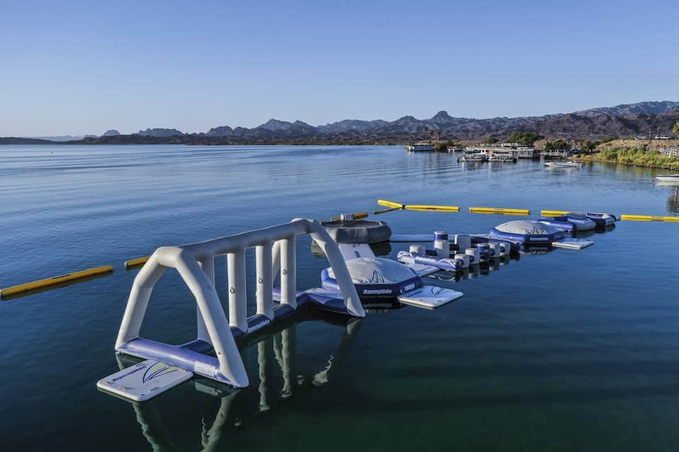 Water sports equipment setup on calm blue lake with mountains in background and waterfront buildings