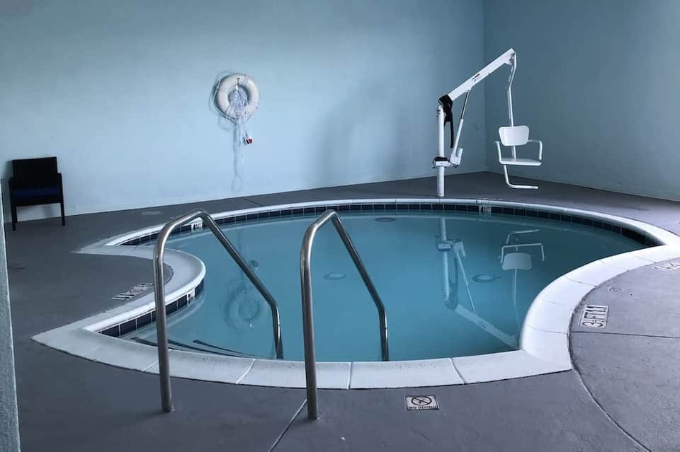 Indoor hot tub with metal railings and spa facilities in minimalist room setting