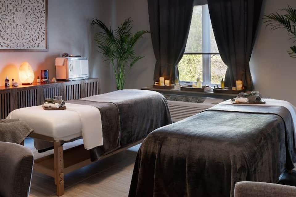Spa treatment room with massage beds and wellness ambiance lighting