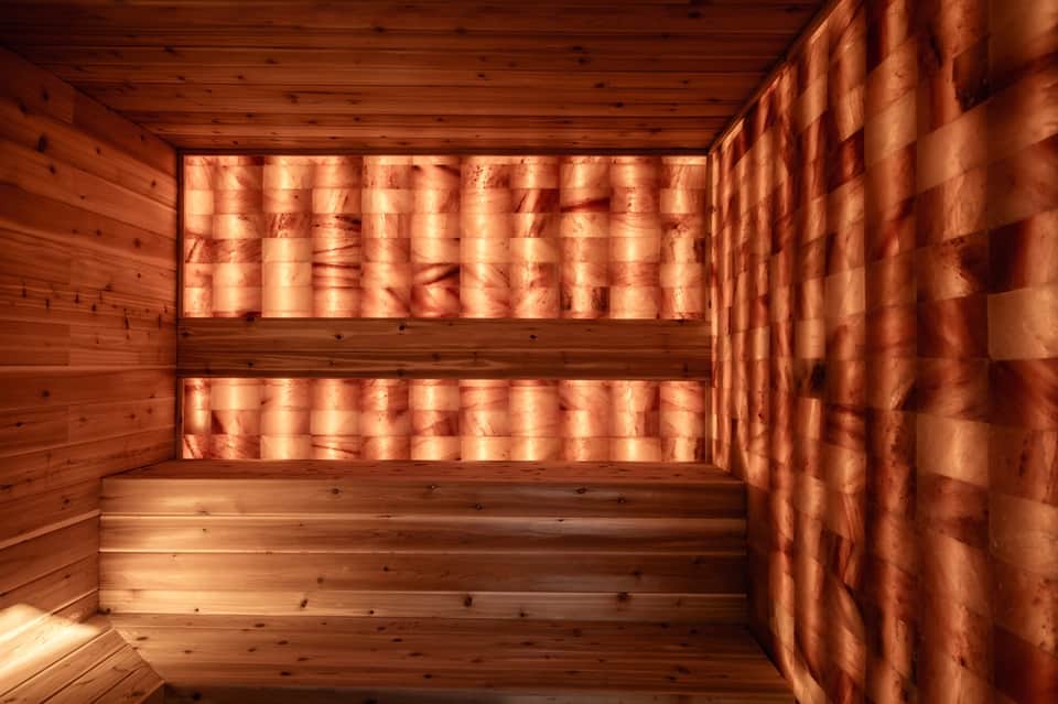 Interior view of wooden sauna with benches and warm amber lighting