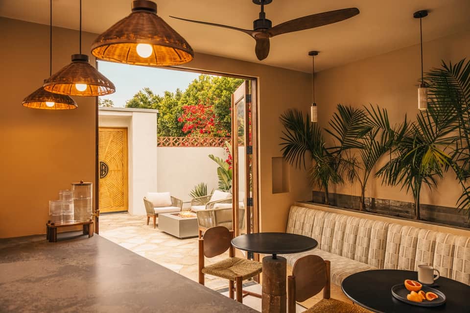Modern lounge area with woven pendant lights, terracotta walls, and open courtyard view