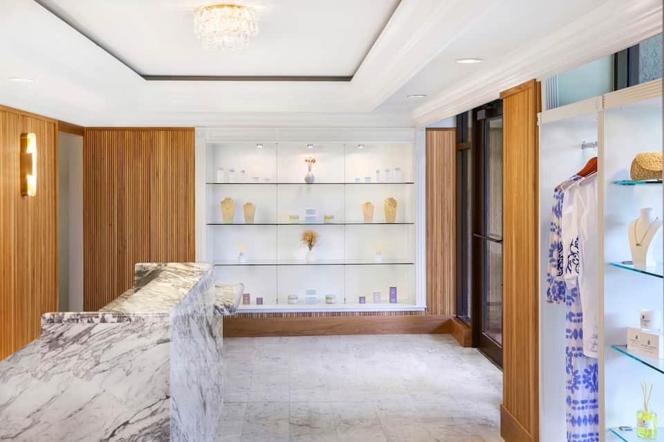 Upscale retail boutique with marble counter, wood accents, and glass display cases