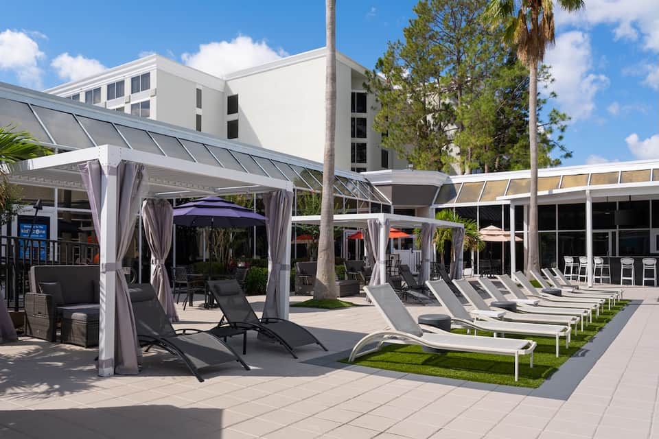 Modern resort patio with cabanas, shade structures, lounge chairs, and contemporary architecture