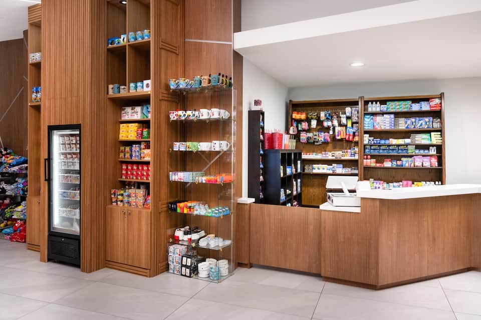 Resort gift shop interior with wooden shelving, display cases, and counter area well stocked