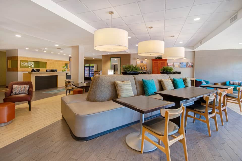 Hotel lobby with modern seating, pendant lighting, and reception desk