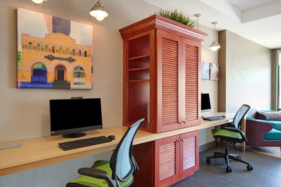 Modern business center with desk, computer, red cabinet, and office chairs