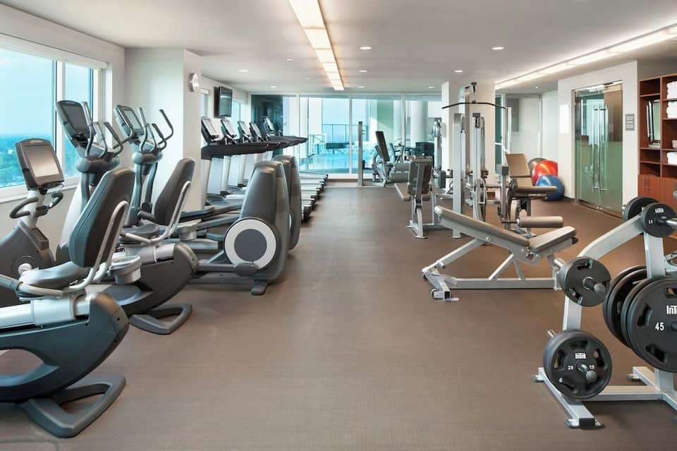 Modern hotel fitness center with cardio equipment and ocean views