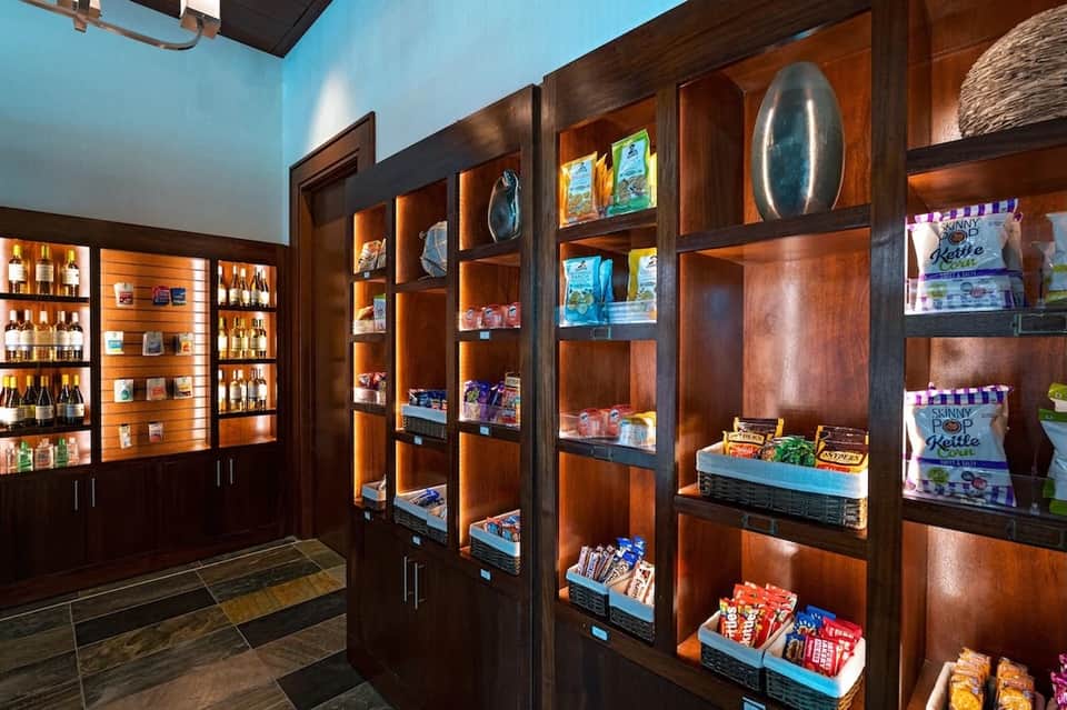 Upscale retail shop interior with dark wood shelving, illuminated display cases, and product merchandise